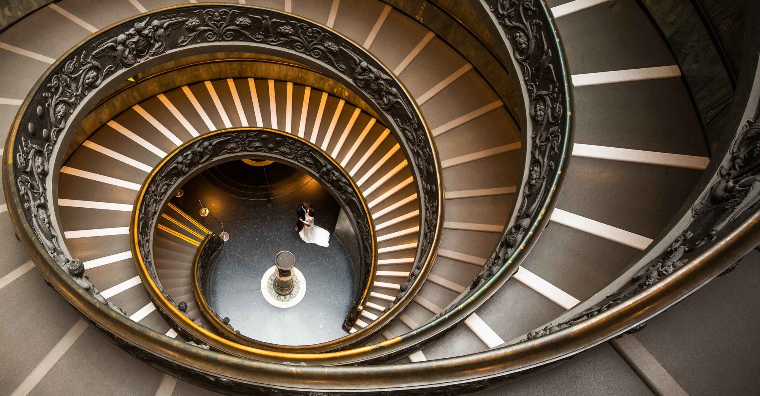 Hone, Portfolio, RomAntik, Dolce Vita, Ernst Merkhofer Exclusive, Fotograf, Rom , Exlusive, Signature Shot, Ernst Merkhofer, Pärchen, junges Paar, Foto Session, Photo Shoot, Staircase, Love, Portraits, Portrait, Pre Wedding , After Wedding, Hochzeiten, Verliebtes Paar am Ende einer doppel Helix Treppe in Rom, eng umschlungen.