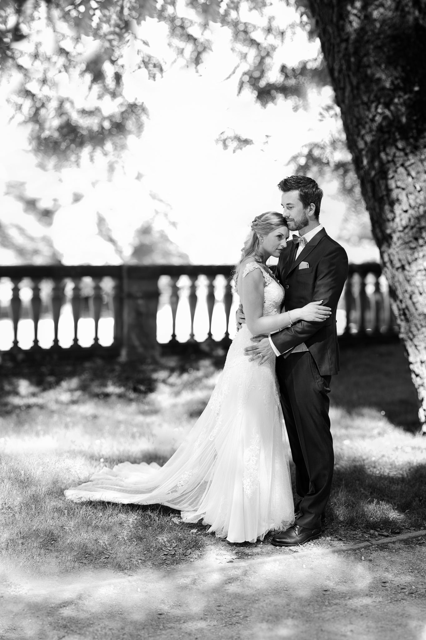 Brautpaar steht und hält sich leicht umschlungen fest. Kulisse Schloßgarten in Heidelberg. After Wedding Session.