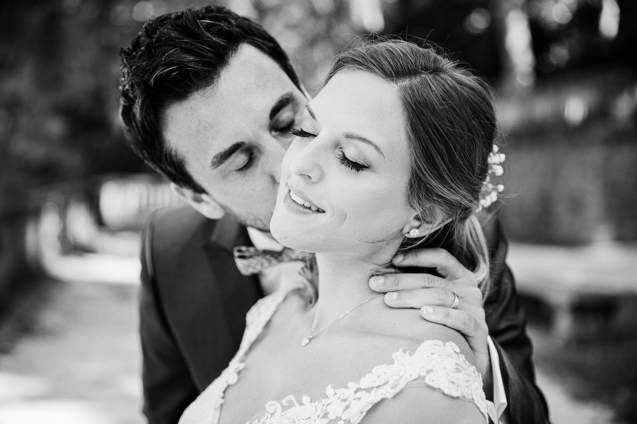 Junges Brautpaar, er küßt sie auf die Wange, sie genießt die Zärtlichkeit mit geschloßenen Augen. Entspannte After Wedding Session.