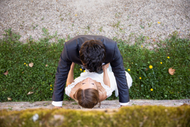 Braut und Bräutigam stehen sich an einer Mauer gegenüber, er steht vor ihr. Blick von oben auf das Paar. After Wedding Session.