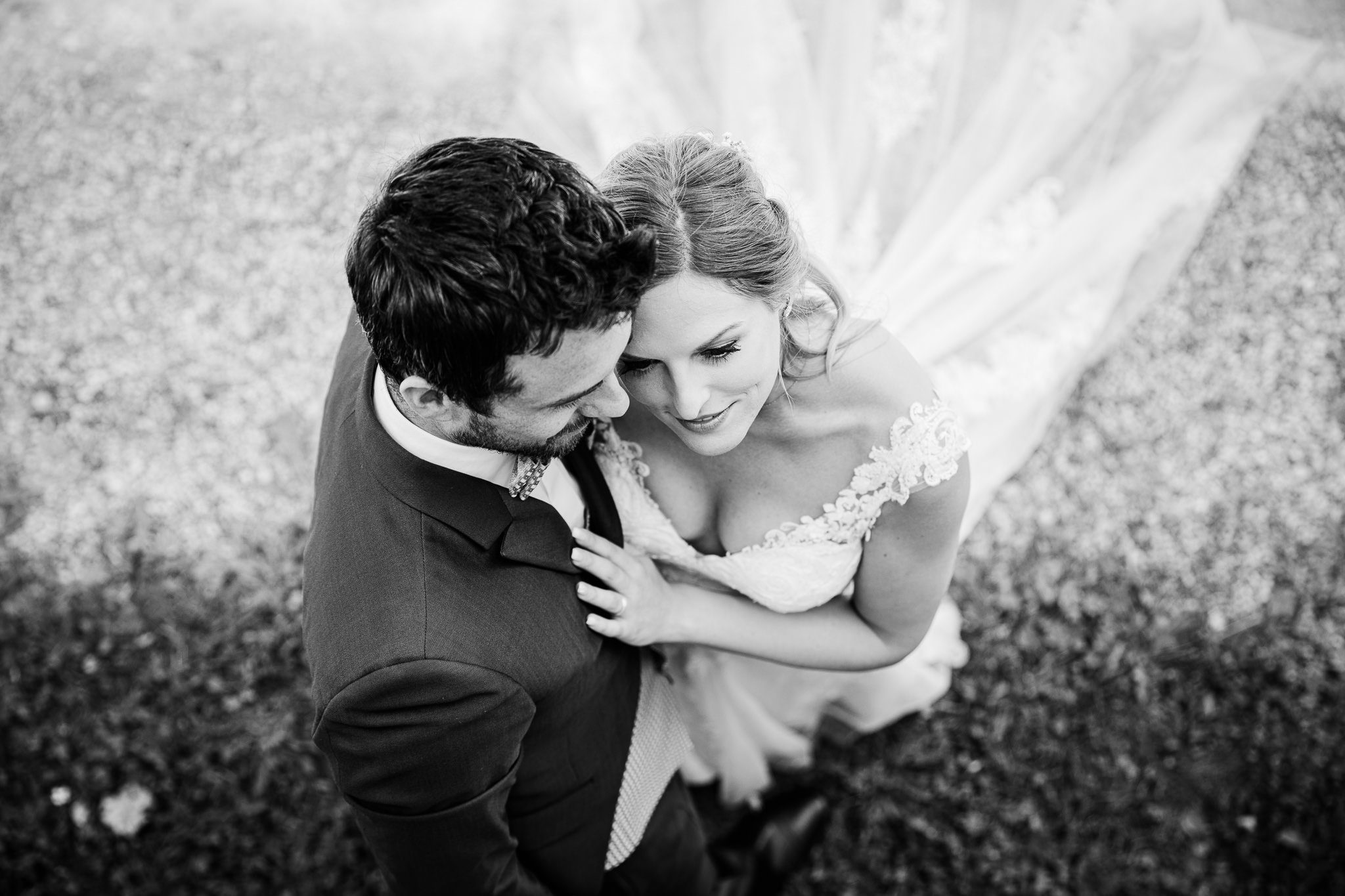 Brautpaar steht innig zusammen Blick von oben auf die Szene, sie berüht ganz leicht den Bräutigam.