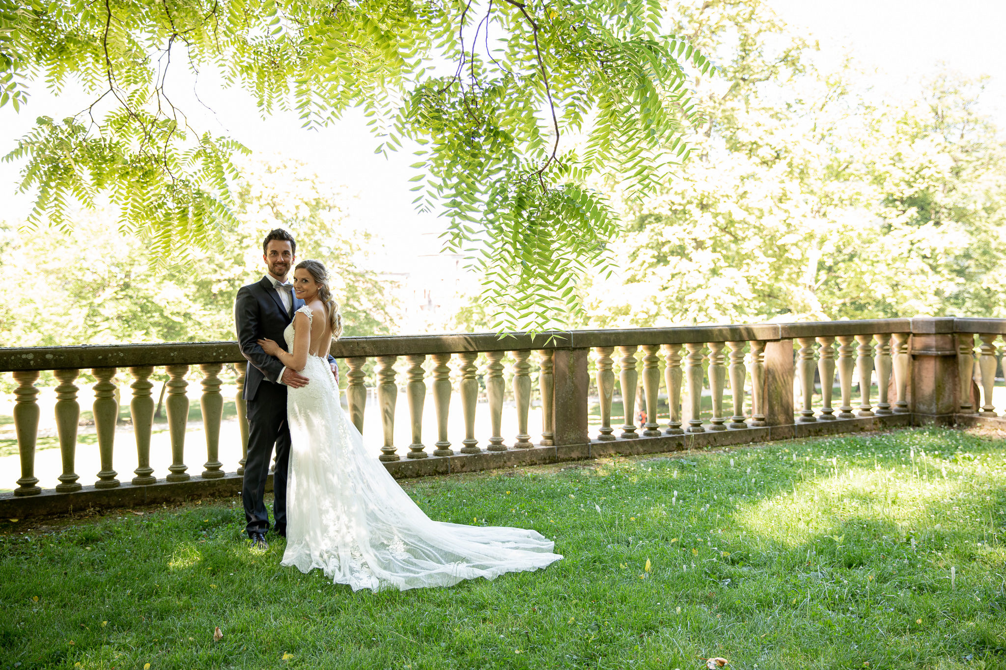 Brautpaar steht eng zusammen und blickt in die Kamera. Schlossgarten Heidelberg. After Wedding Session.