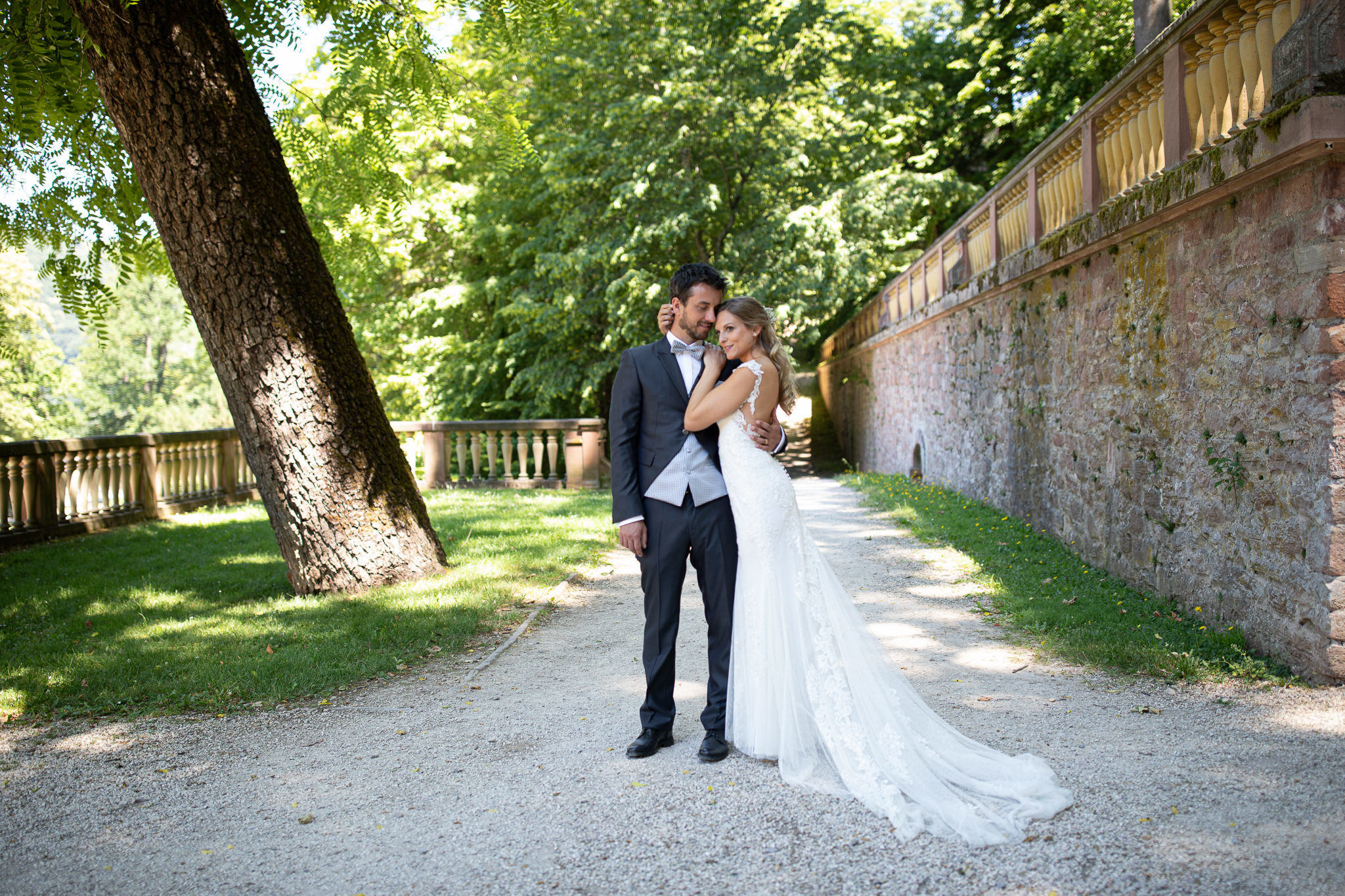 Braut schmiegt sich an den Bräutigam. After Wedding Session im Heidelberger Schlosspark.